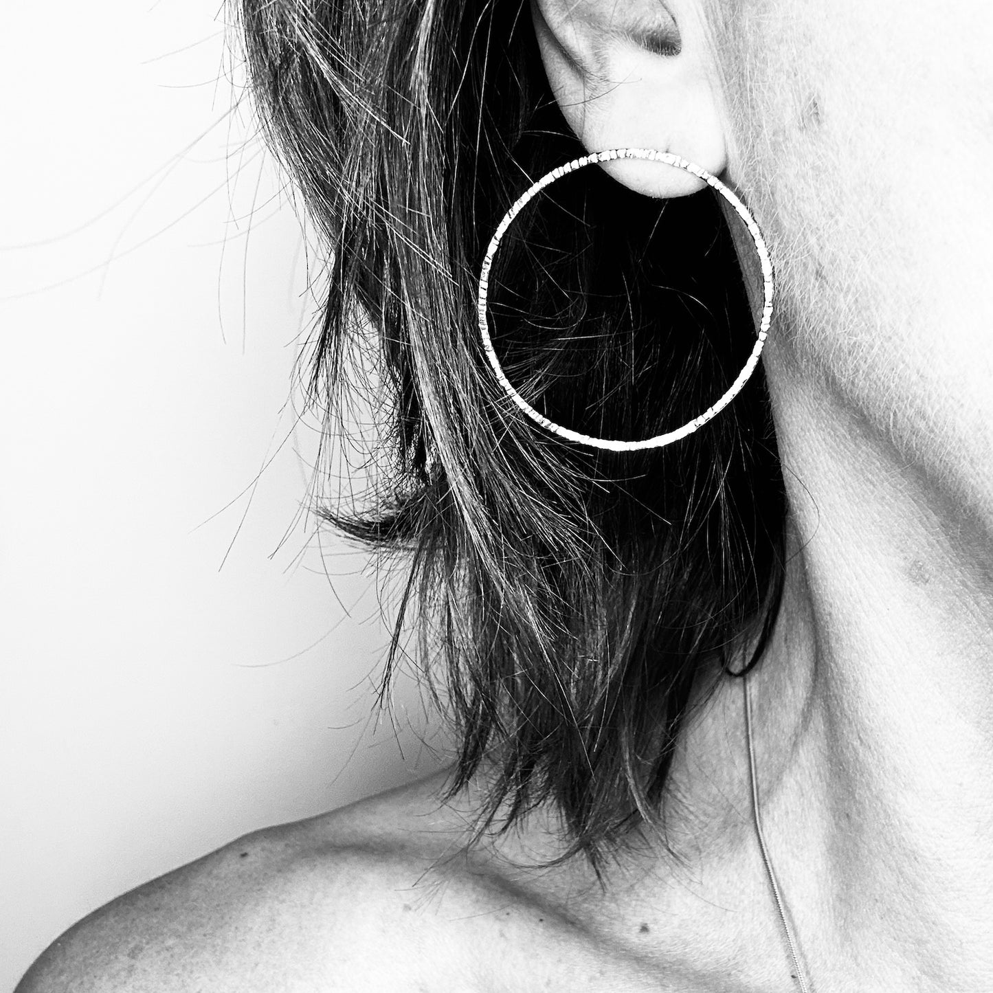 Woman wearing 40mm 9ct gold hoop earring - lightweight statement style