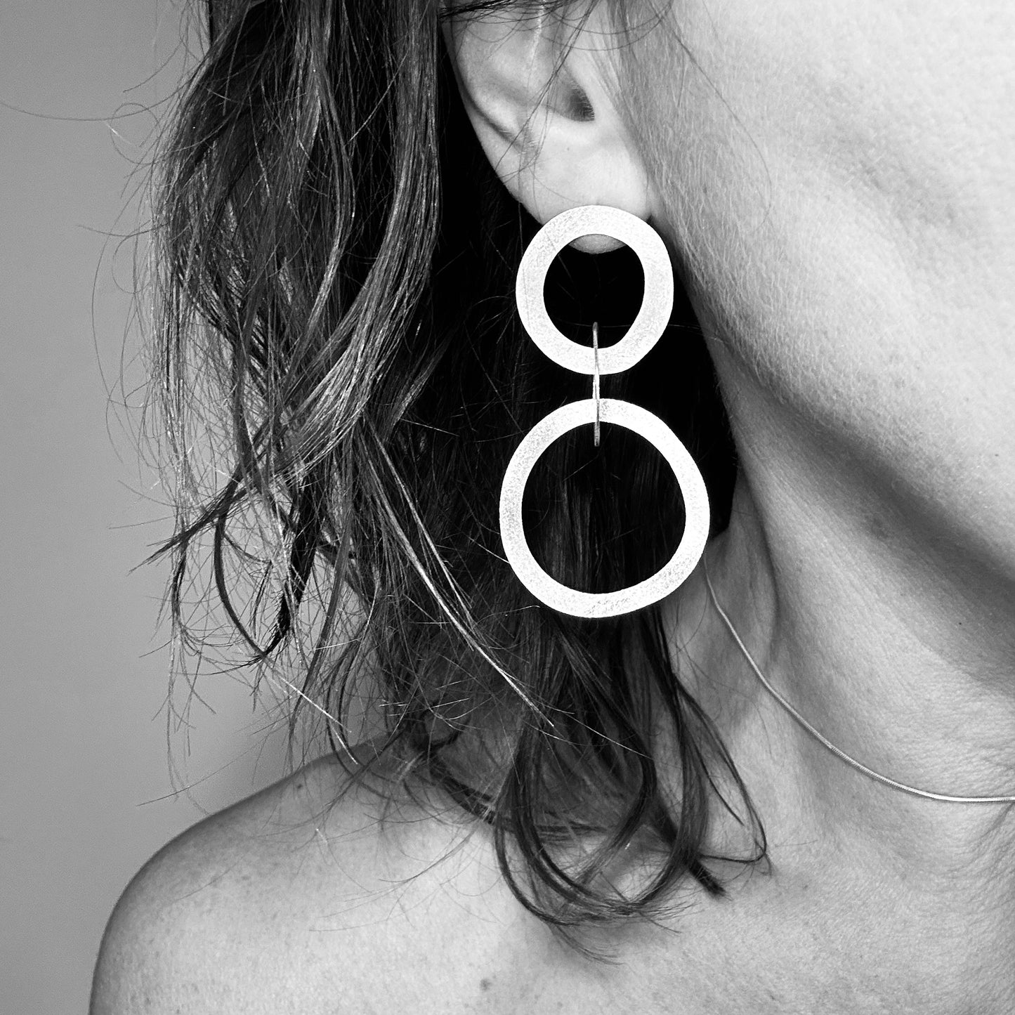 Woman wearing double circle drop earring - handmade silver hoops