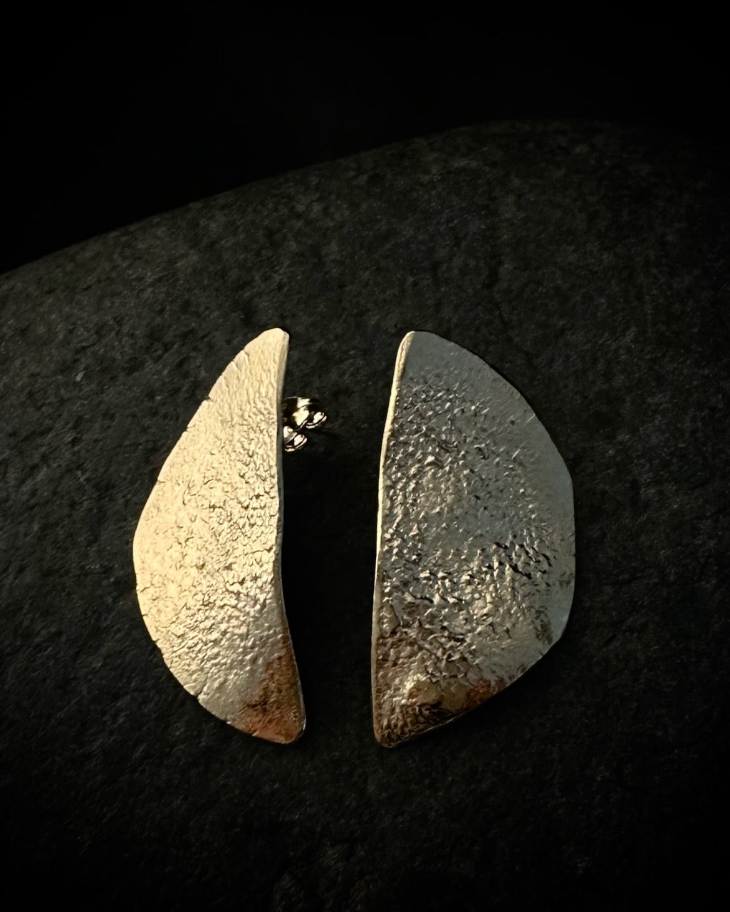 Textured gold plated half moon stud earrings in recycled sterling silver on dark background