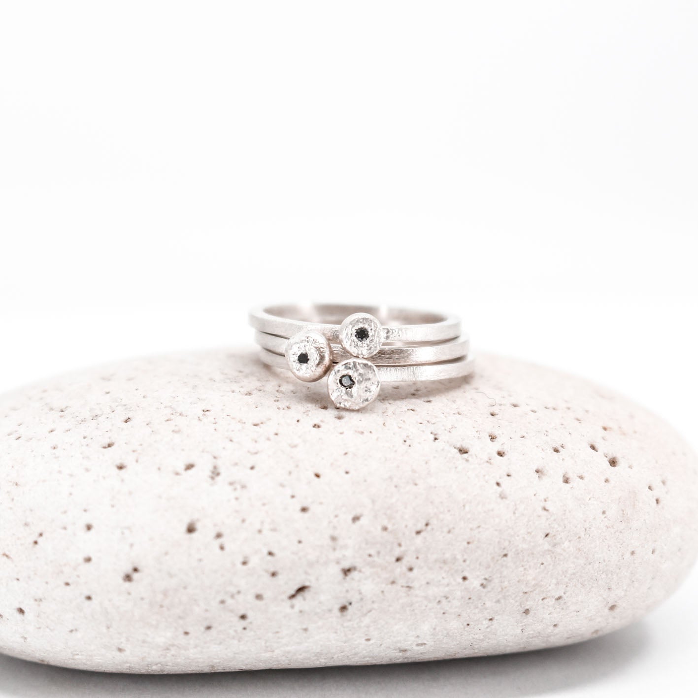 three simple silver stacking rings with each a set black diamond, sabine Werner jewellery