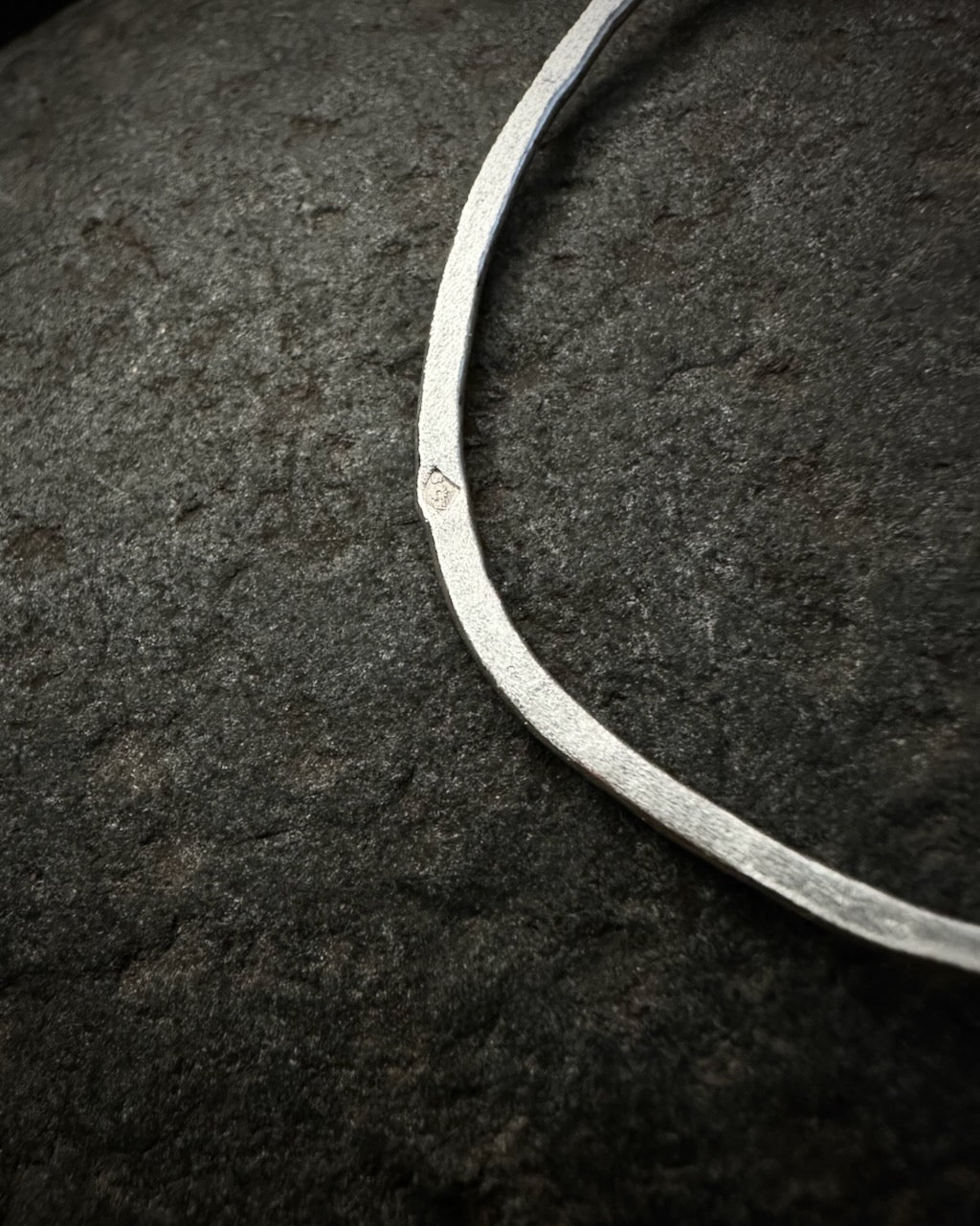 Detail of textured sterling silver earring with maker’s mark