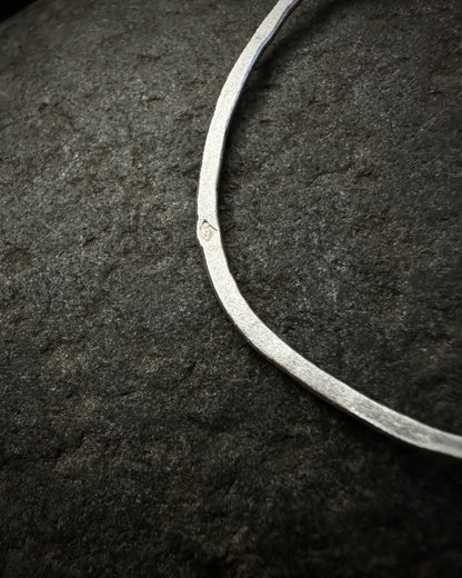 Detail of textured sterling silver earring with maker’s mark
