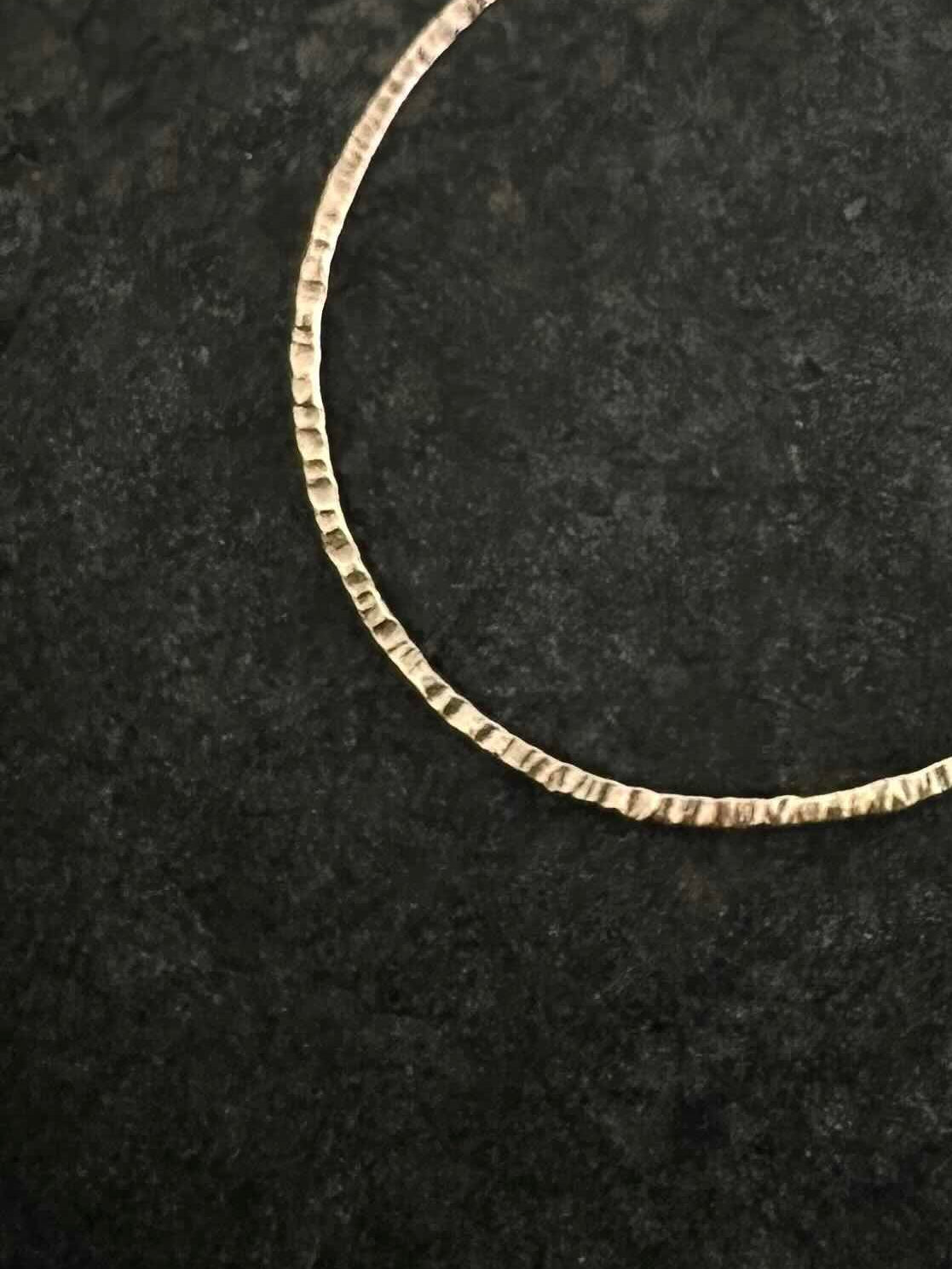 9ct gold hoop earring close-up - hammered texture detail