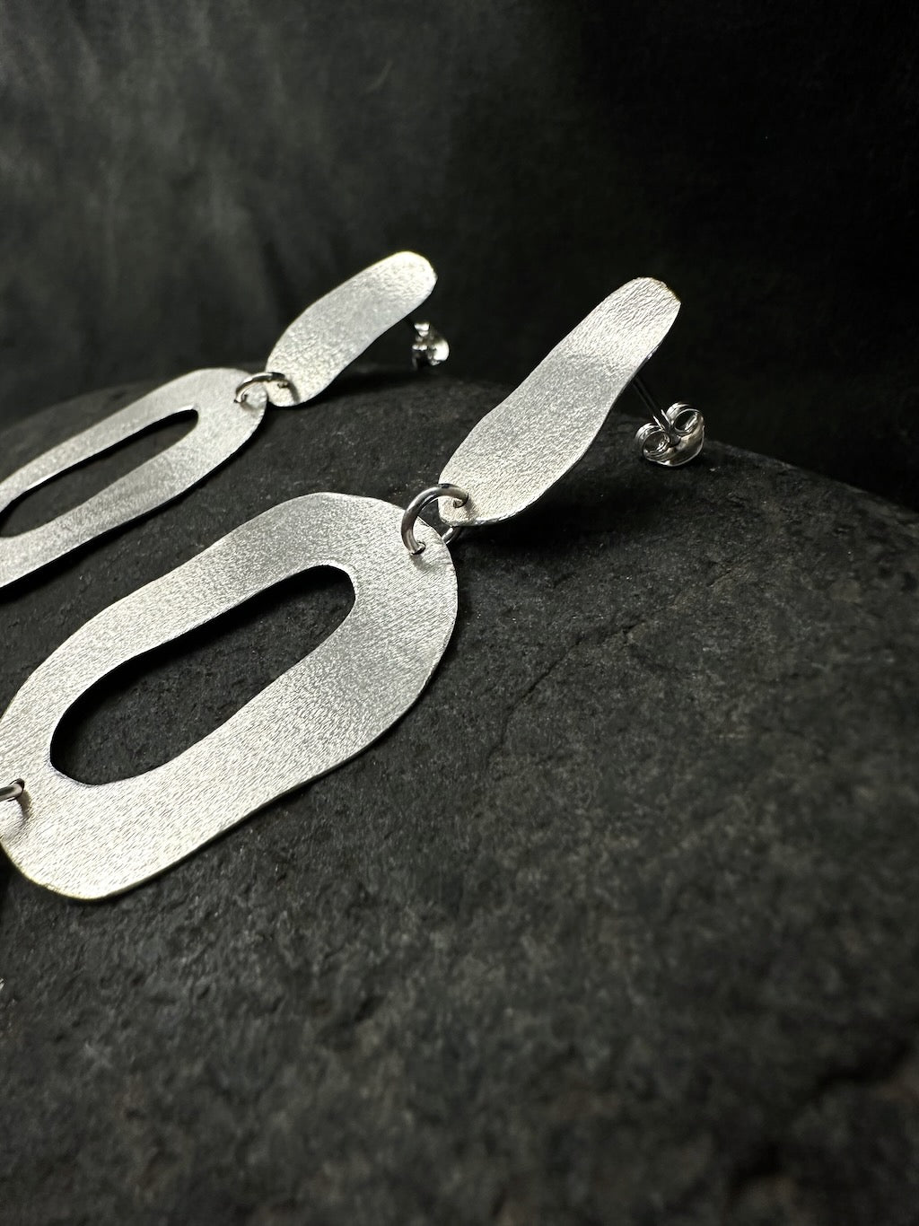 Side view of sterling silver oval earrings showing post and butterfly back