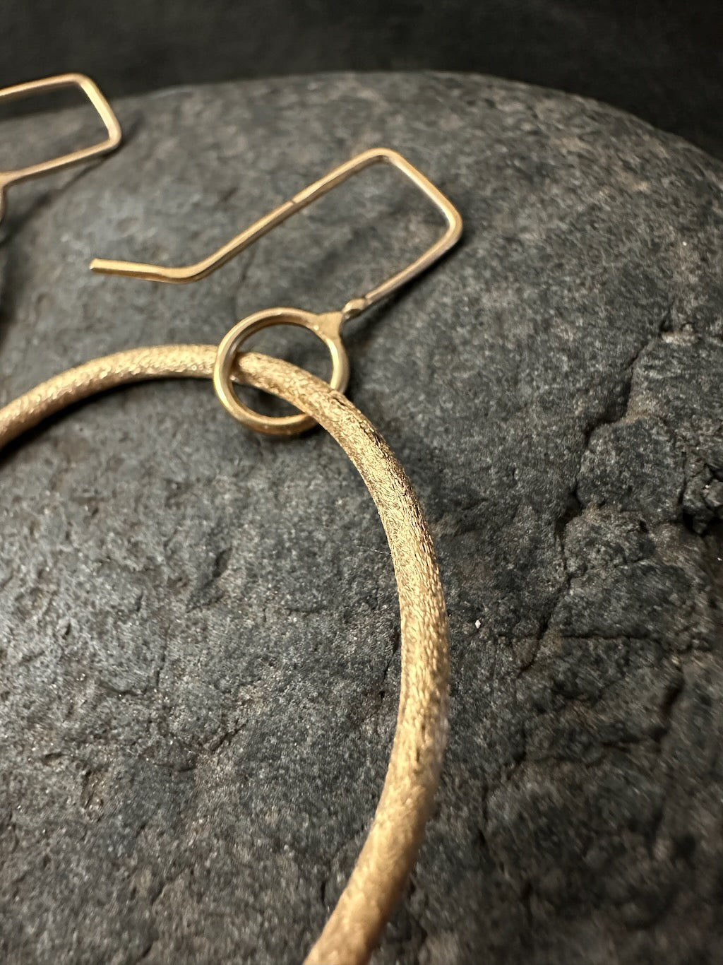 Close-up of ear wire and connector ring on gold hoop earrings