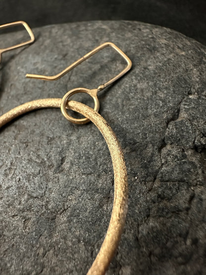 Close-up of ear wire and connector ring on gold hoop earrings