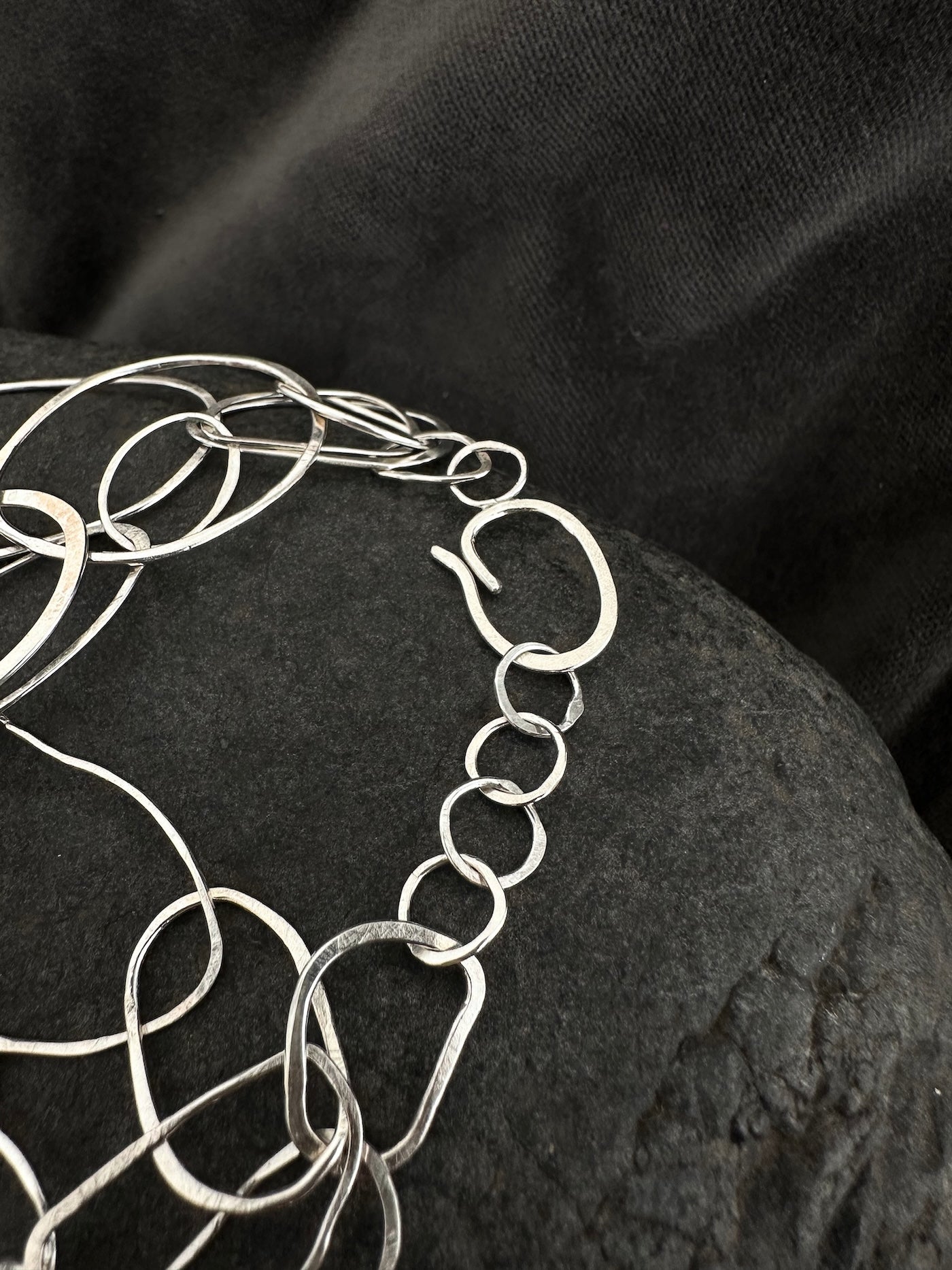 Close-up of adjustable chain clasp on sterling silver loop bracelet
