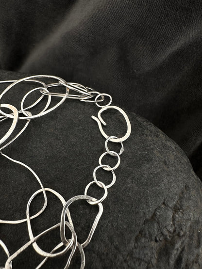 Close-up of adjustable chain clasp on sterling silver loop bracelet
