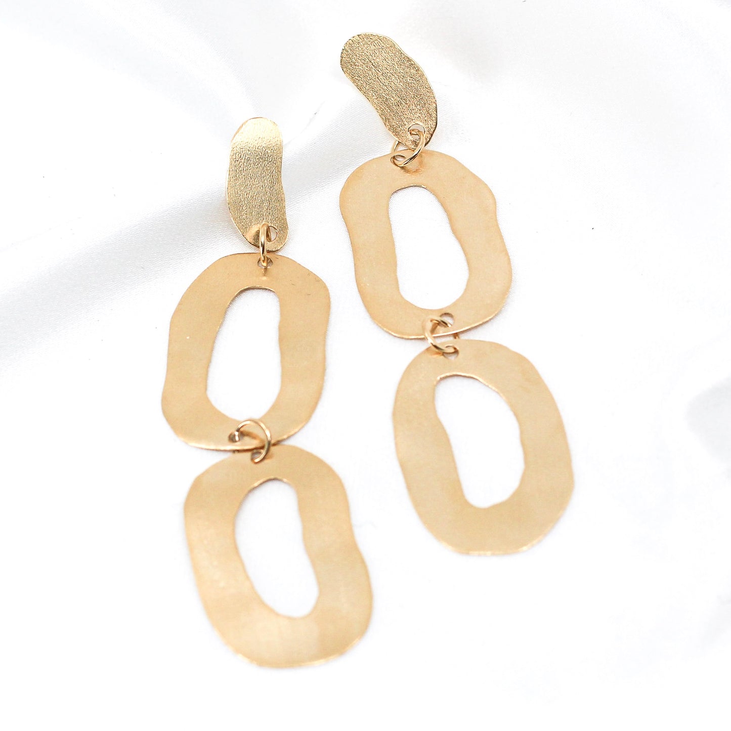 long dangly gold earrings with organic shapes