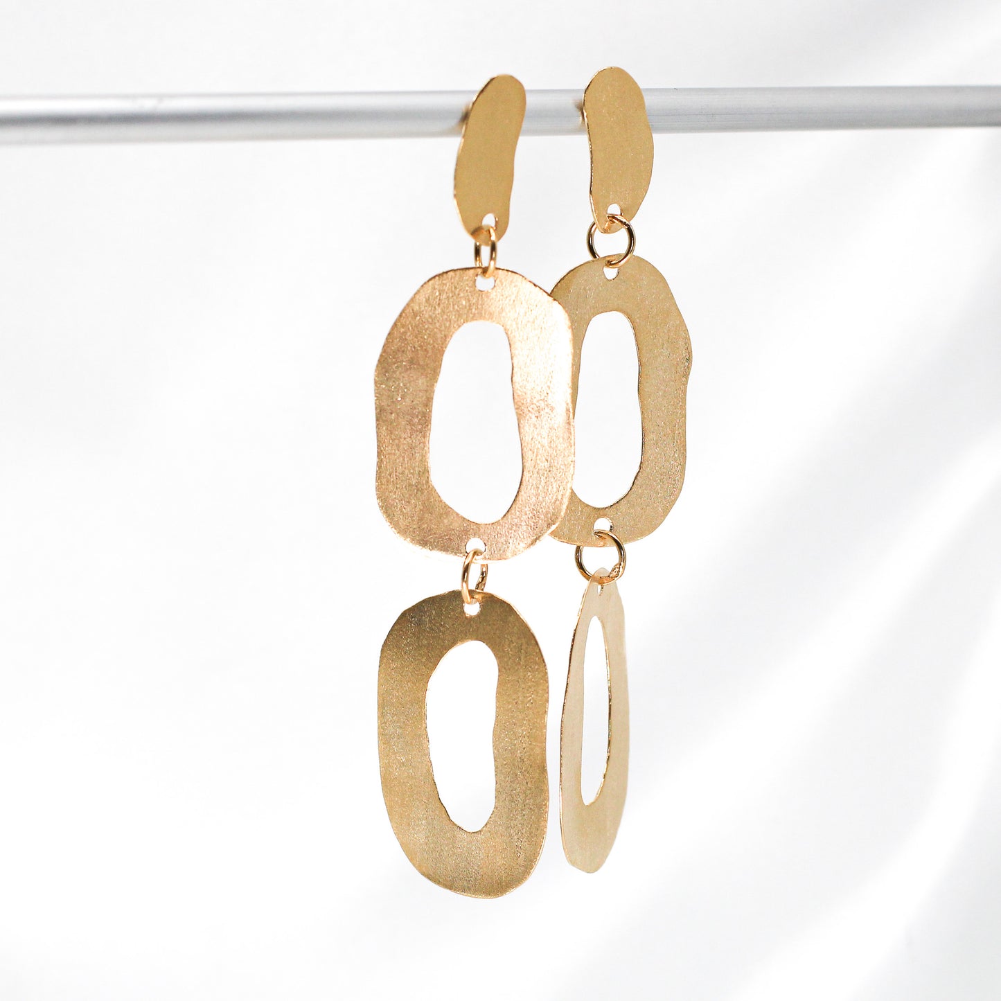 long dangly gold earrings with organic shapes