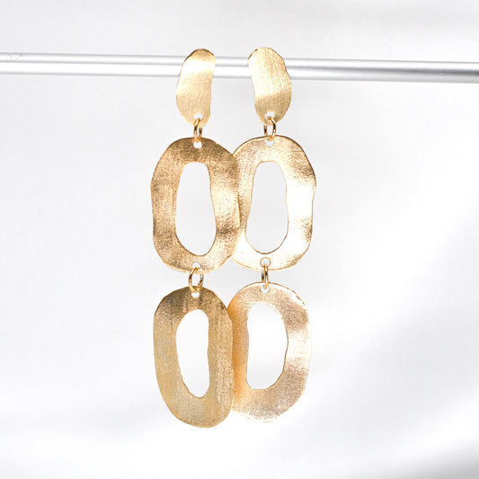long dangly gold earrings with organic shapes