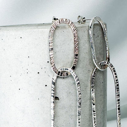 long oval dangly silver earrings in hammered structure