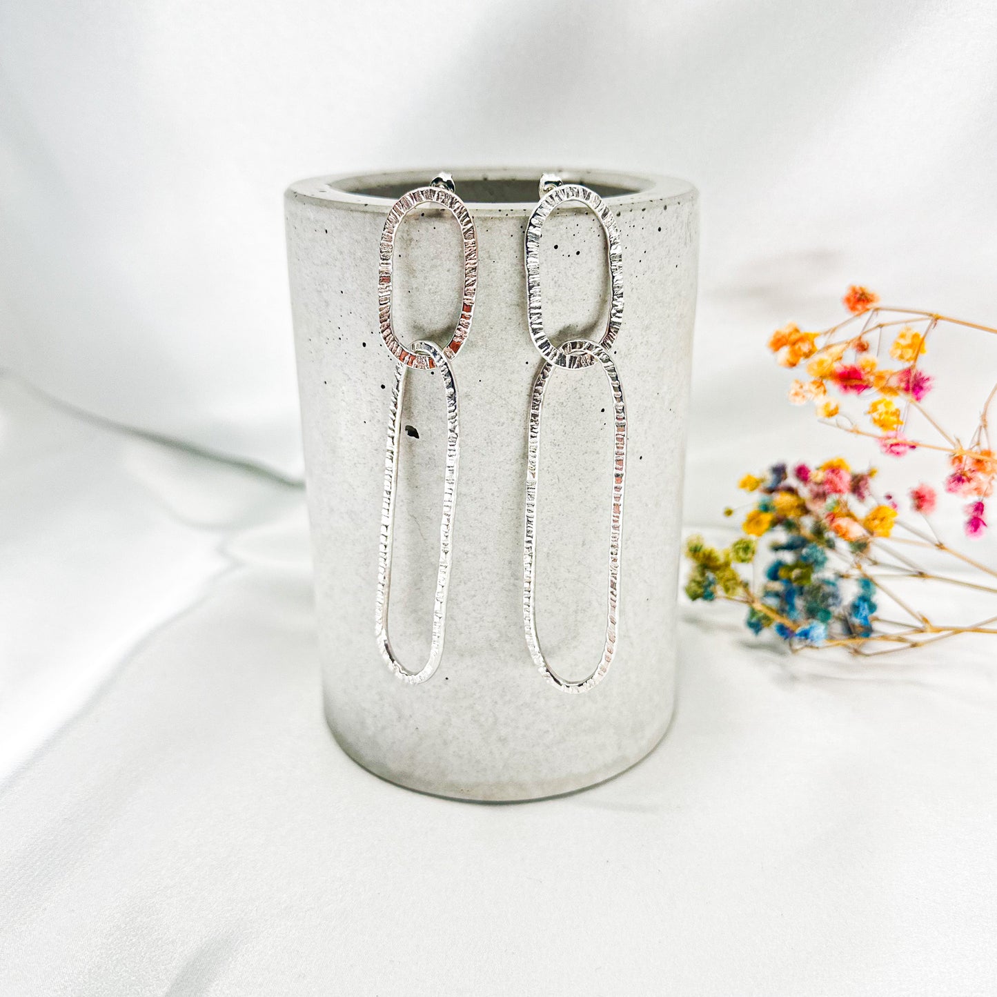 long oval dangly silver earrings in hammered structure