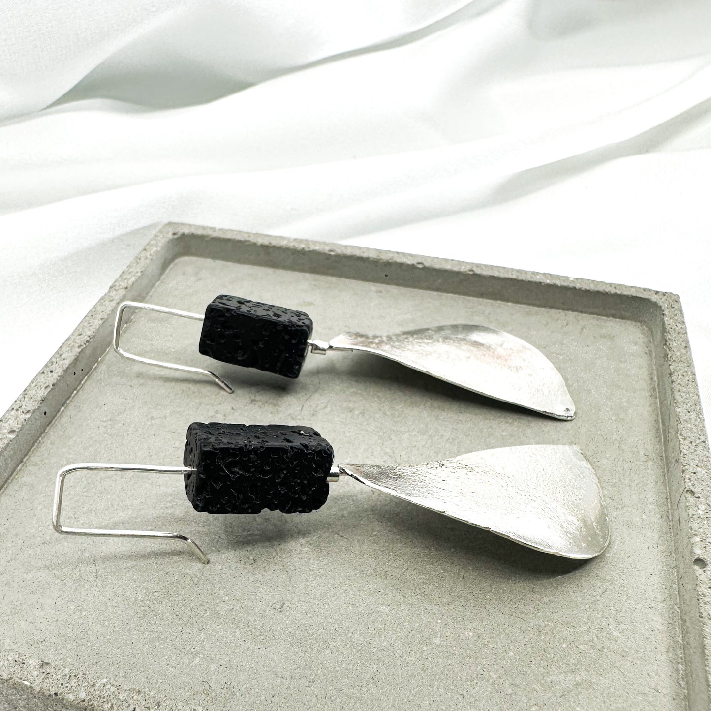 long dangly silver earrings with black lava stone