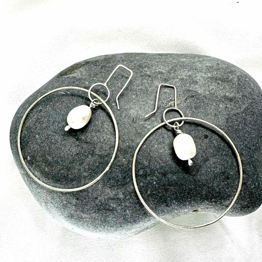 Large handmade silver hoop earrings with baroque pearl drop – minimalist sculptural jewellery by Sabine Werner
