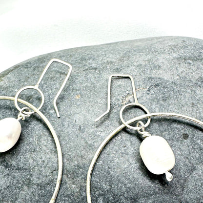 Large handmade silver hoop earrings with baroque pearl drop – minimalist sculptural jewellery by Sabine Werner