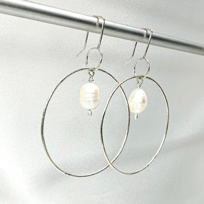 Large handmade silver hoop earrings with baroque pearl drop – minimalist sculptural jewellery by Sabine Werner