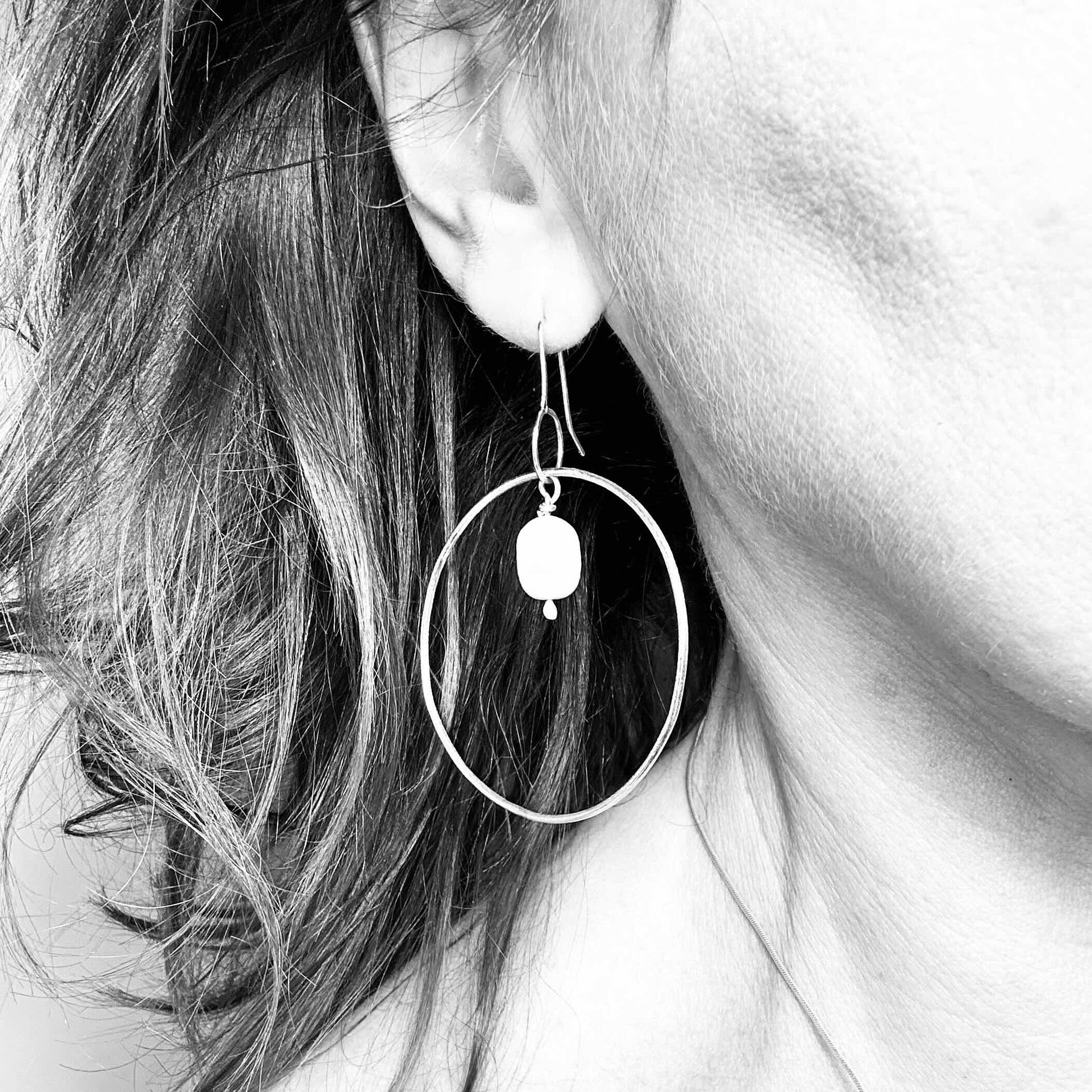 Large handmade silver hoop earrings with baroque pearl drop – minimalist sculptural jewellery by Sabine Werner