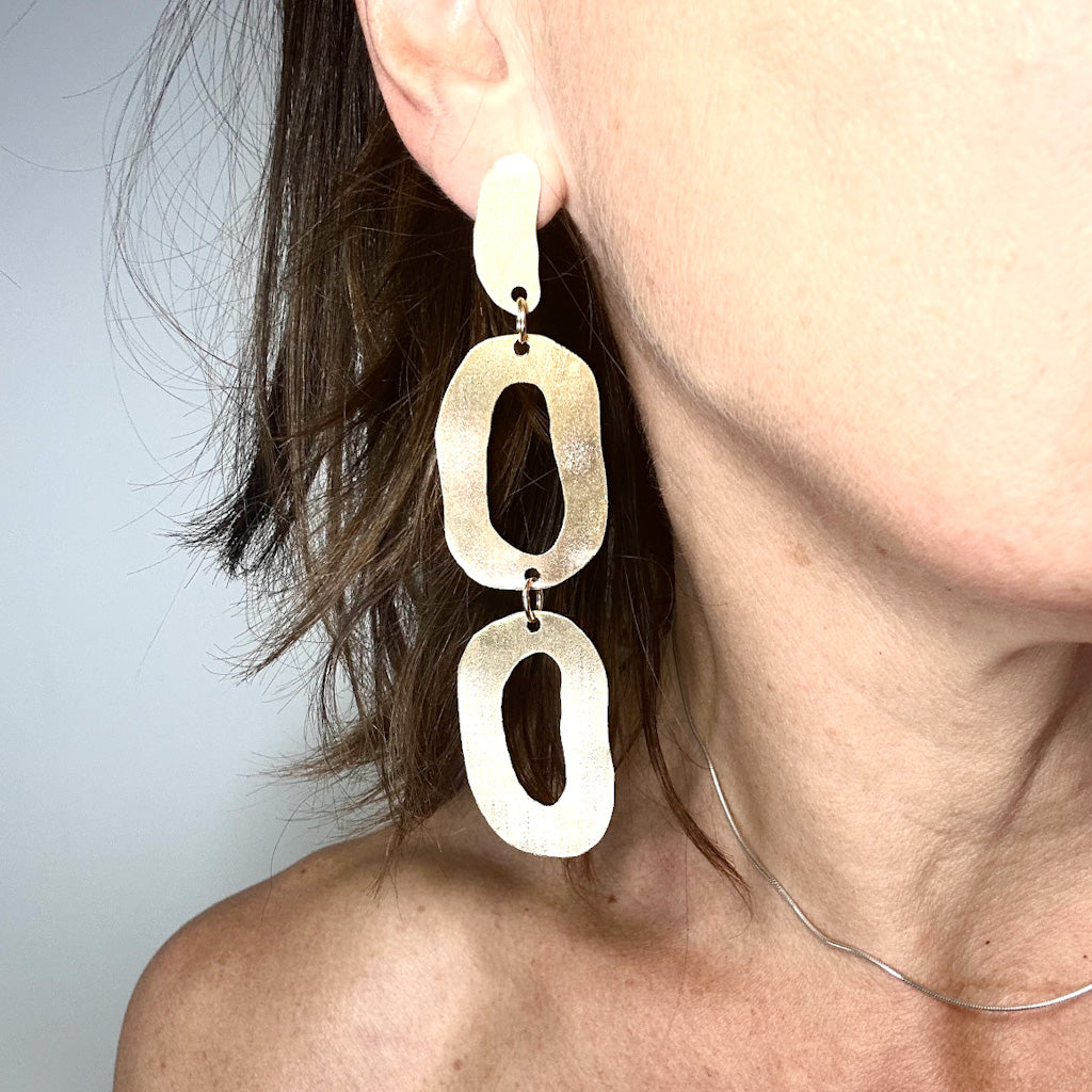 long dangly gold earrings with organic shapes