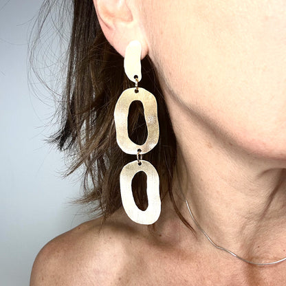 long dangly gold earrings with organic shapes