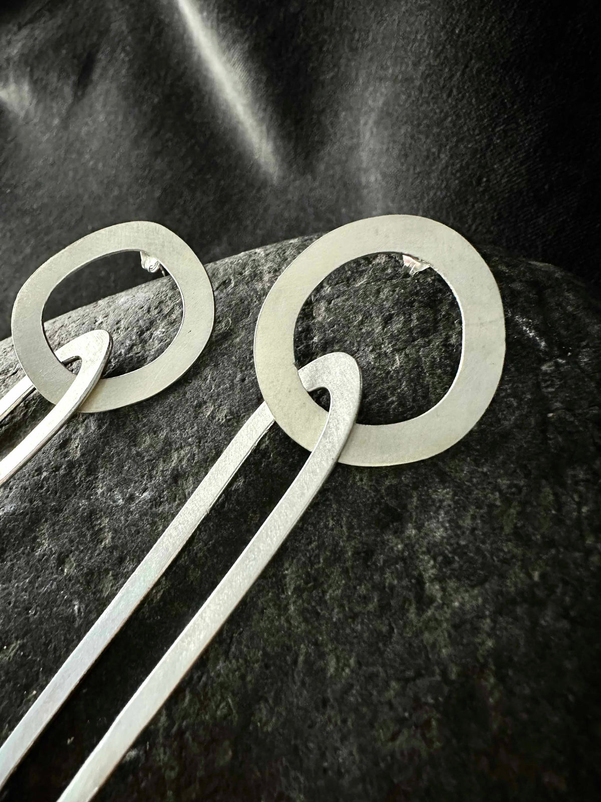 Detail of an organic circle stud interlocking with an oval link, recycled 925 silver