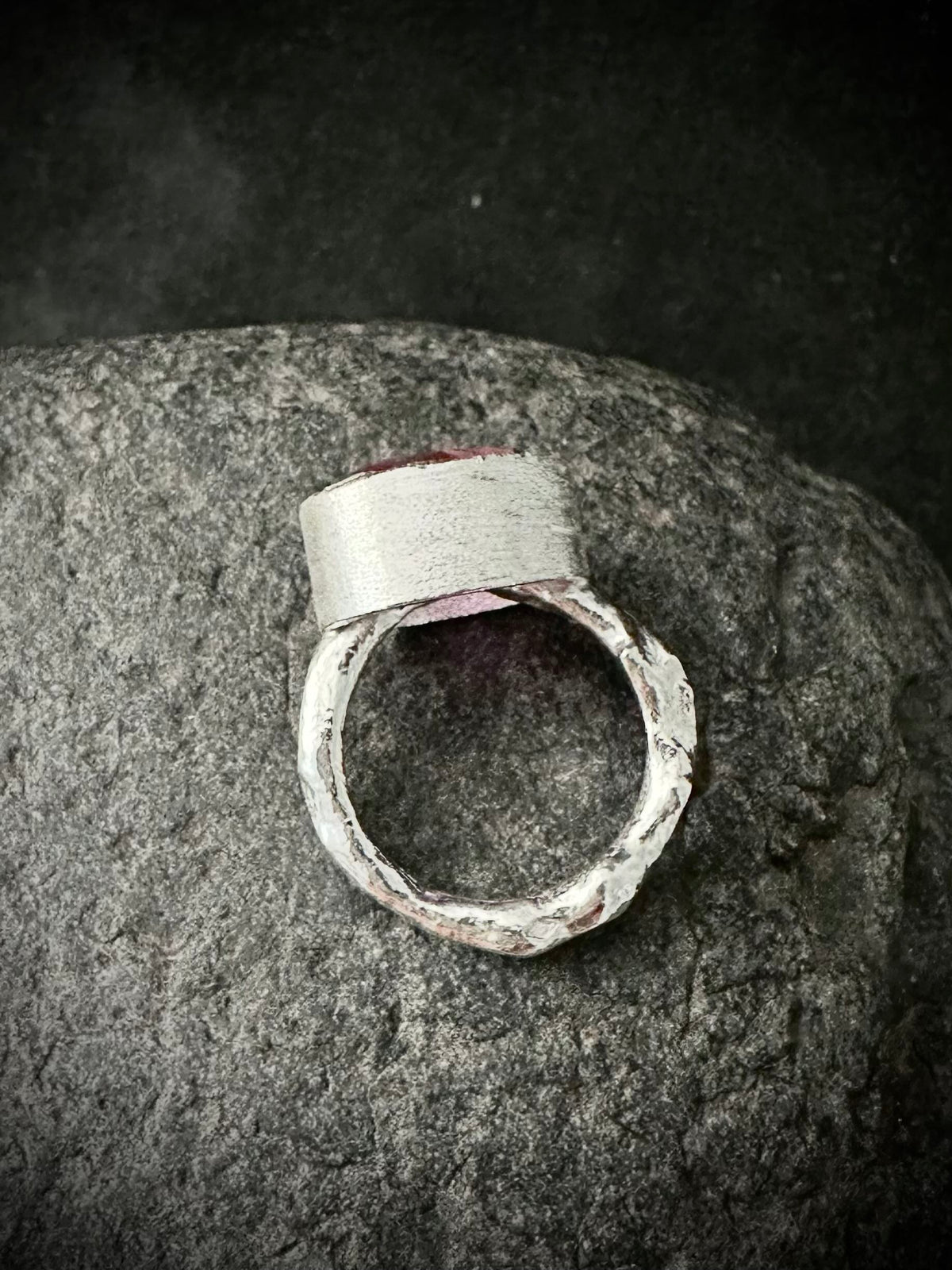 Underside of handmade silver ring showing bezel and molten textured band