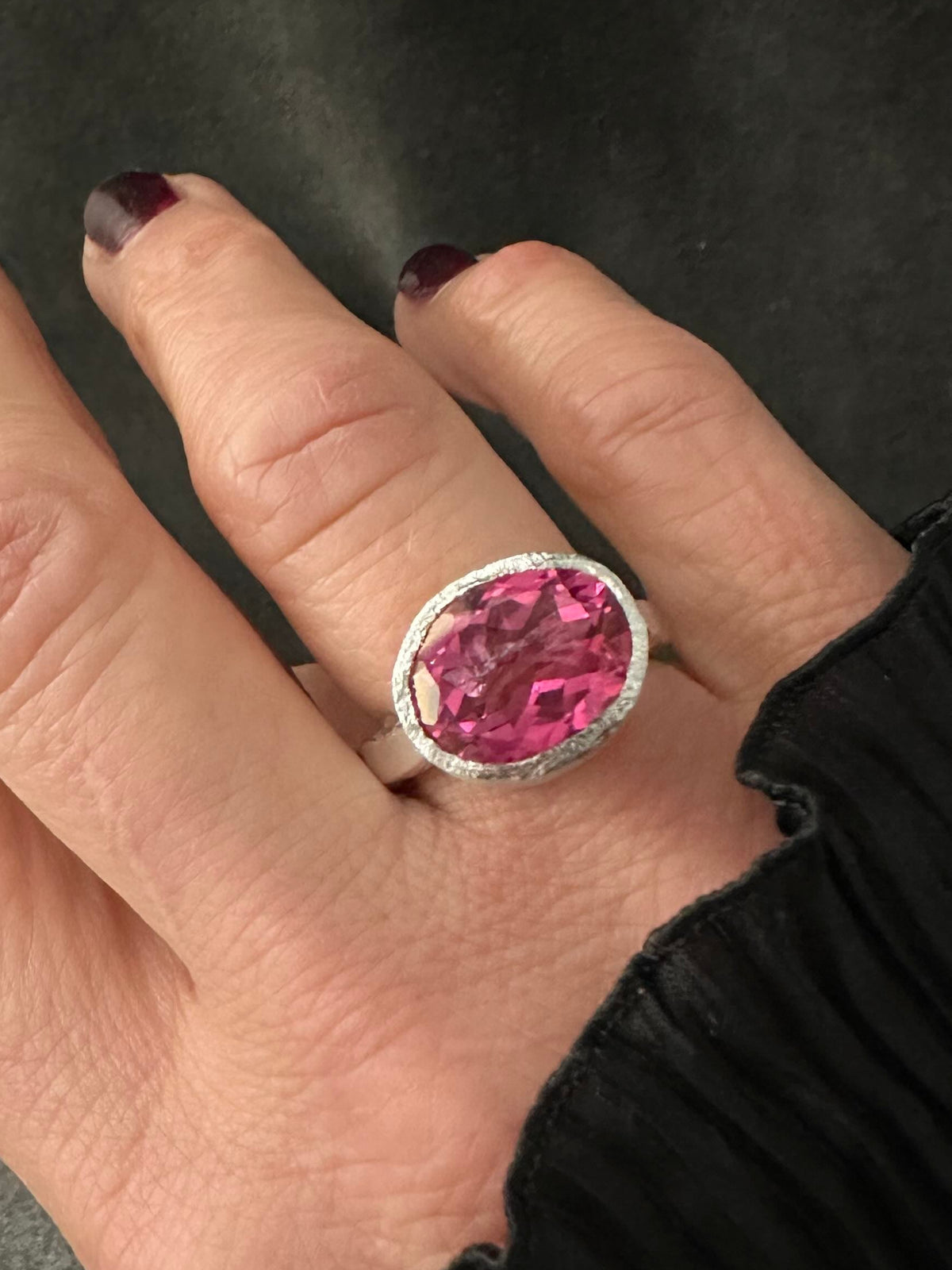 Bold pink topaz statement ring worn on hand, set east-west