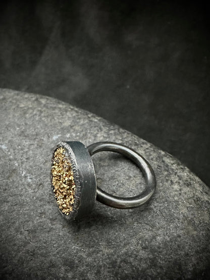 Oxidised sterling silver ring with round band and gold drusy top, angled view