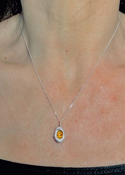 Sterling silver amber pendant necklace worn on chain, minimalist sculptural jewellery