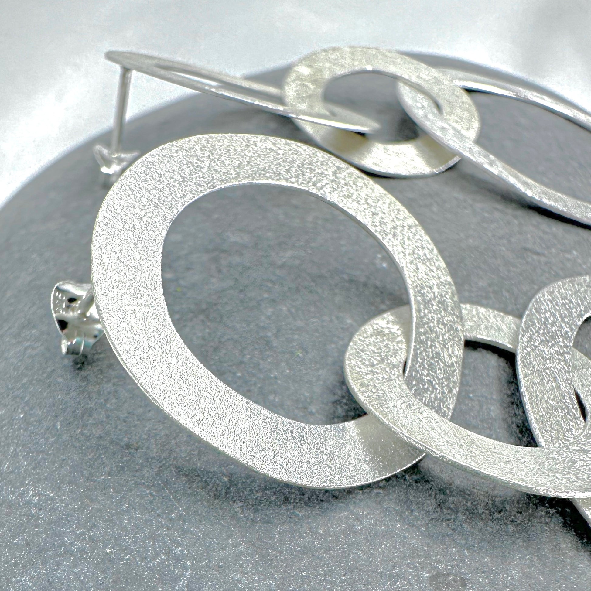 Sterling silver double circle earrings close-up - brushed finish detail