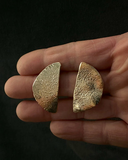 Handmade gold plated half moon stud earrings in recycled sterling silver shown in hand for scale
