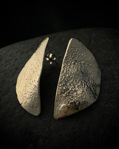 Textured gold plated half moon stud earrings in recycled sterling silver on dark background