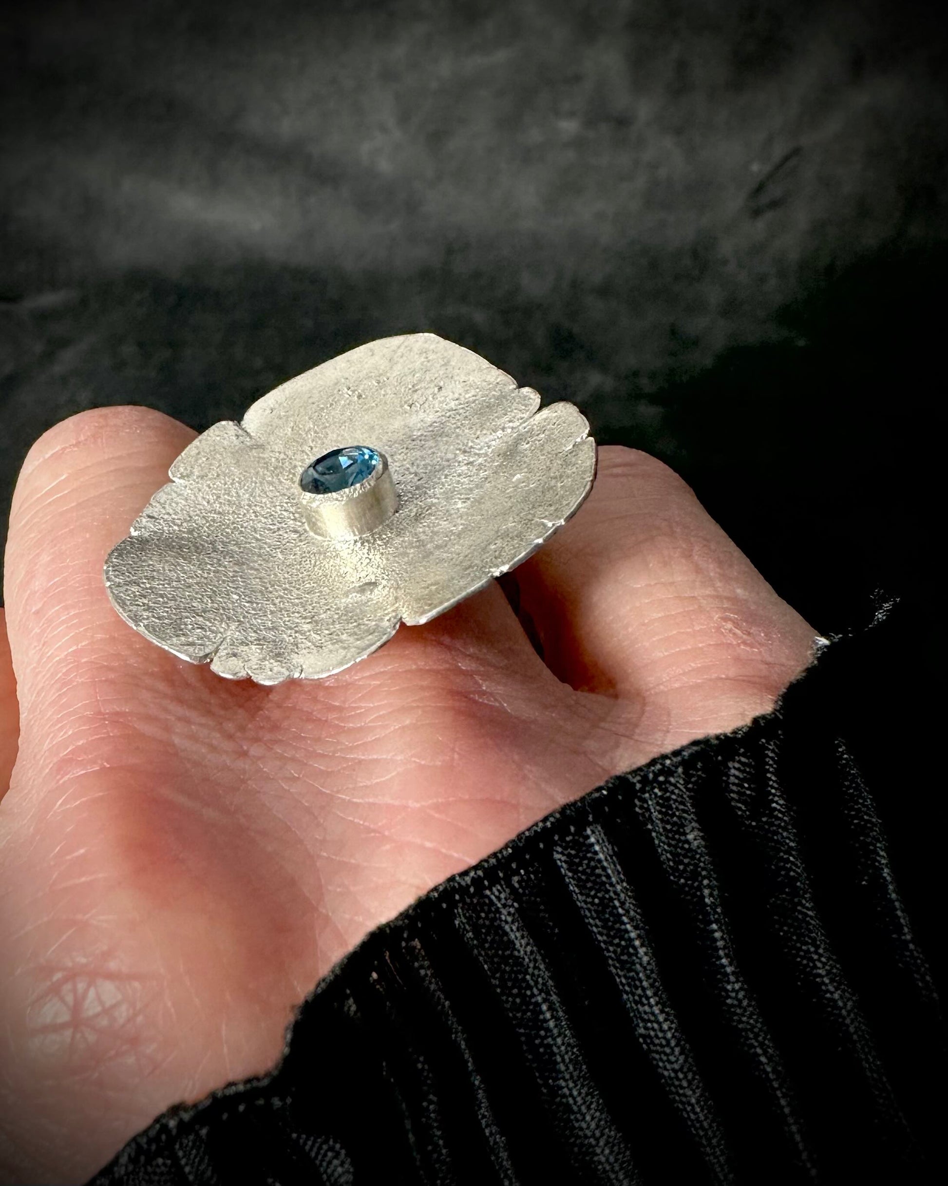 One-of-a-kind large sterling silver ring with blue topaz worn on hand, statement jewellery side