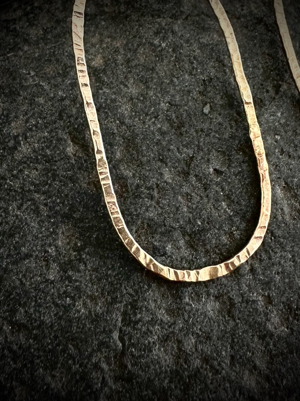9ct gold hoop earring close-up - hammered texture detail