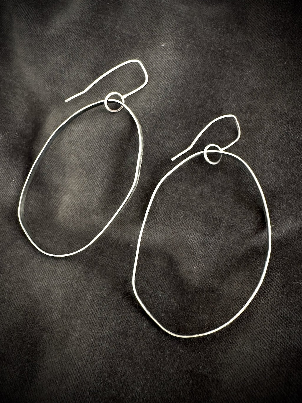 Oxidised silver drop hoop earrings on dark fabric - handmade organic hoops