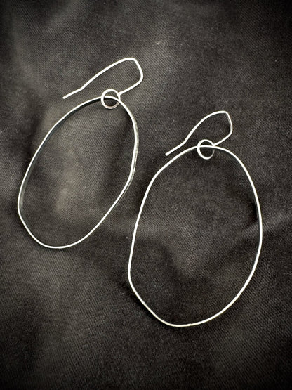 Oxidised silver drop hoop earrings on dark fabric - handmade organic hoops