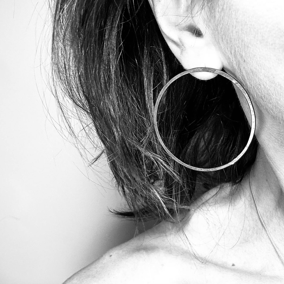 Woman wearing oxidised silver hoop earring - blackened handmade hoop