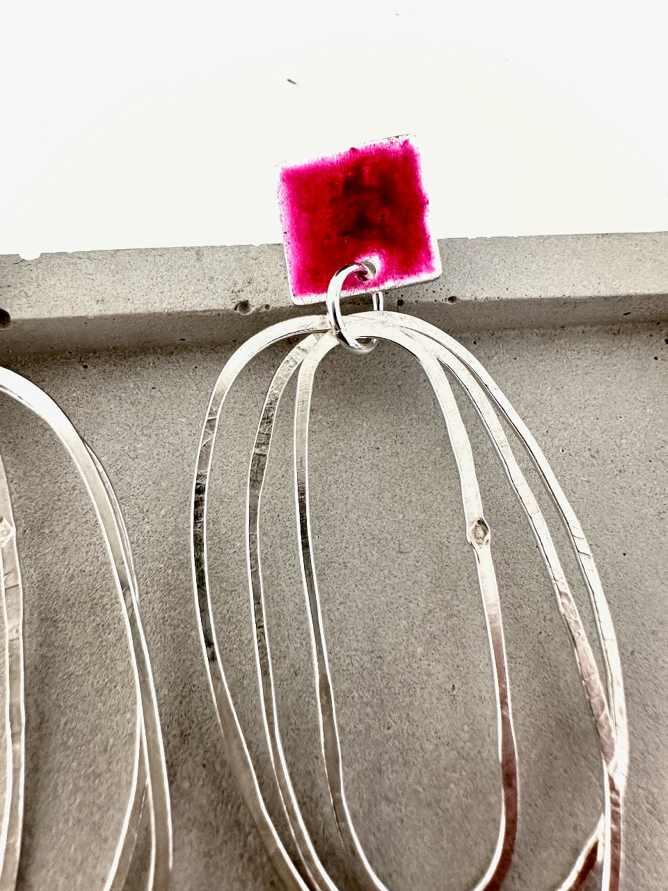 Handmade sterling silver layered oval hoop earring with textured finish and deep pink resin square top
