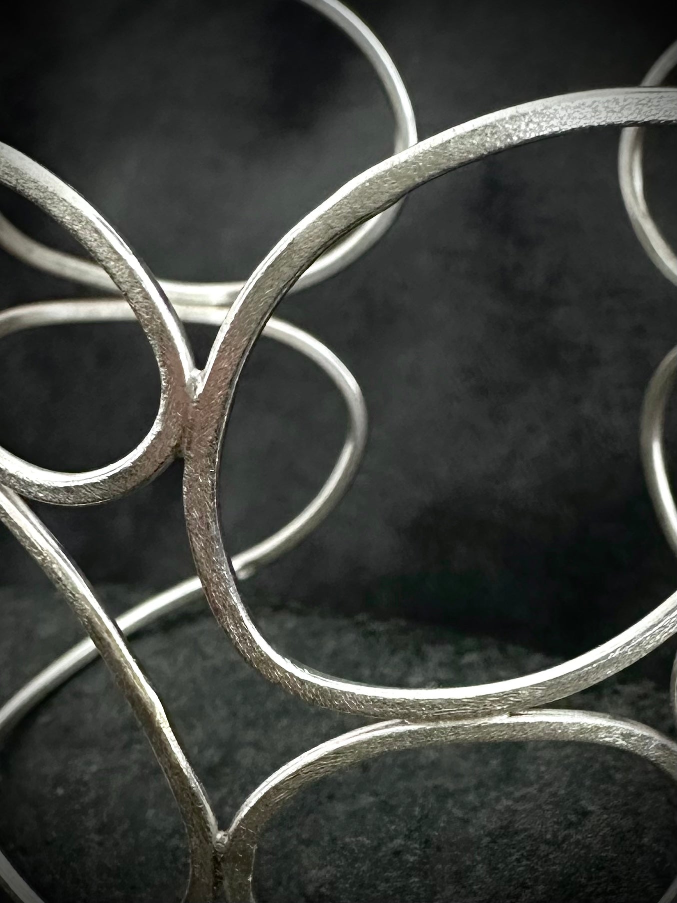 Top view of sculptural sterling silver cuff bangle showing adjustable oval opening