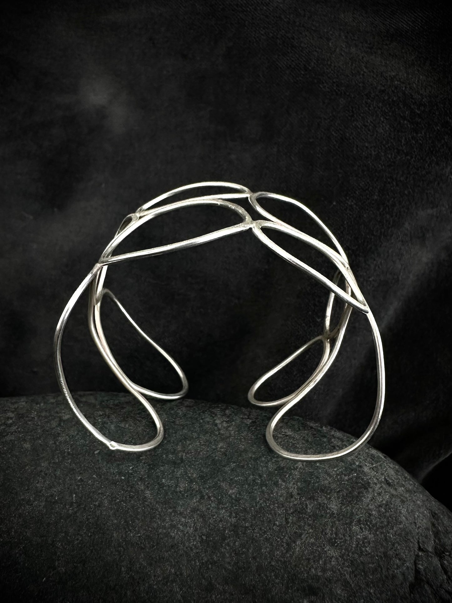 Close-up detail of textured sterling silver cuff bangle showing hand-formed overlapping loops