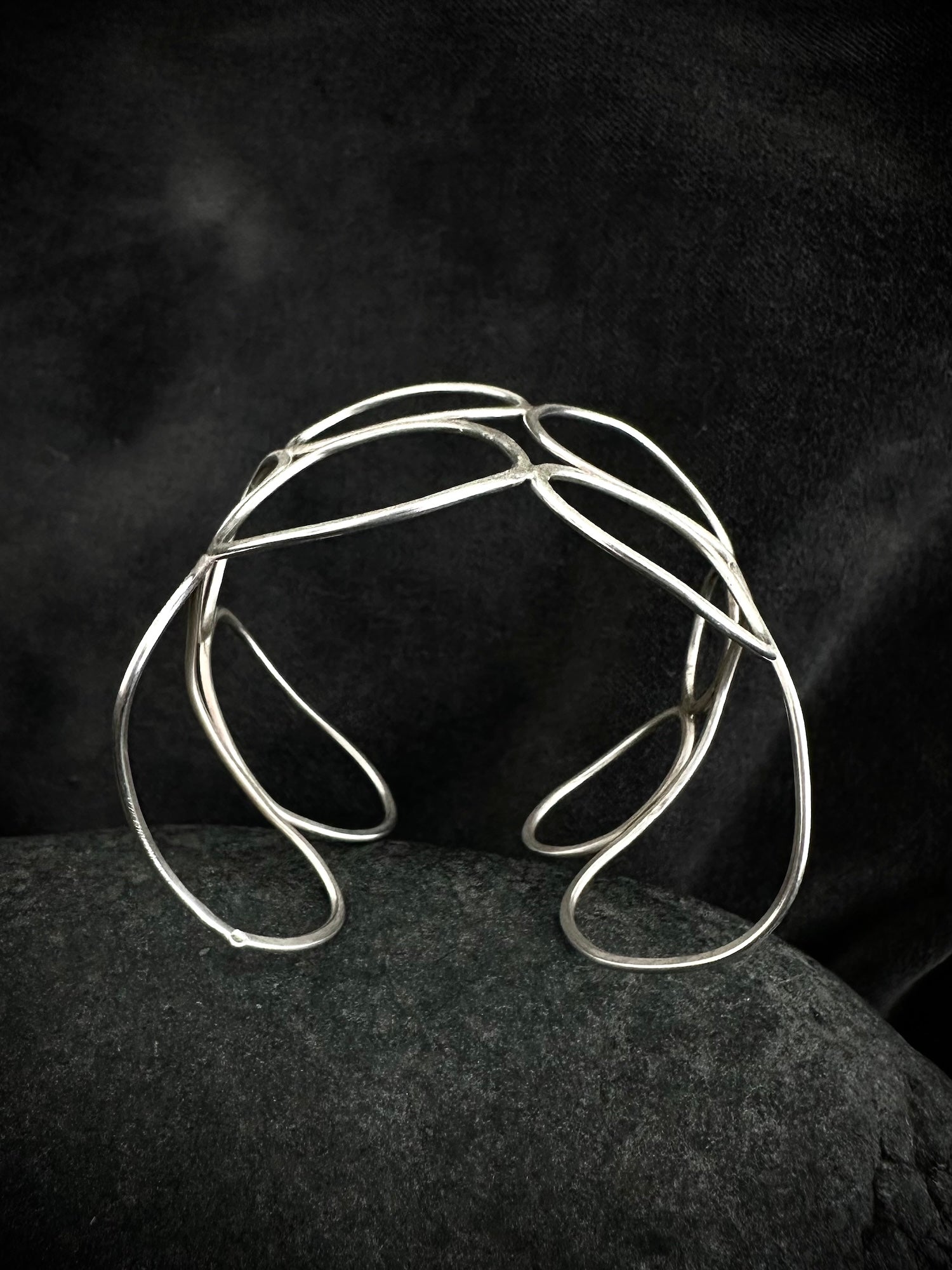 Close-up detail of textured sterling silver cuff bangle showing hand-formed overlapping loops