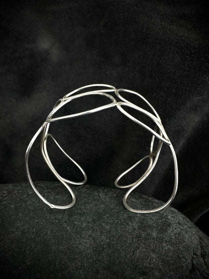 Close-up detail of textured sterling silver cuff bangle showing hand-formed overlapping loops