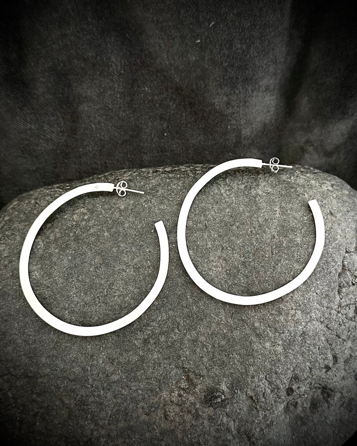 Long sterling silver hoop earrings on dark stone - handmade minimalist jewelry