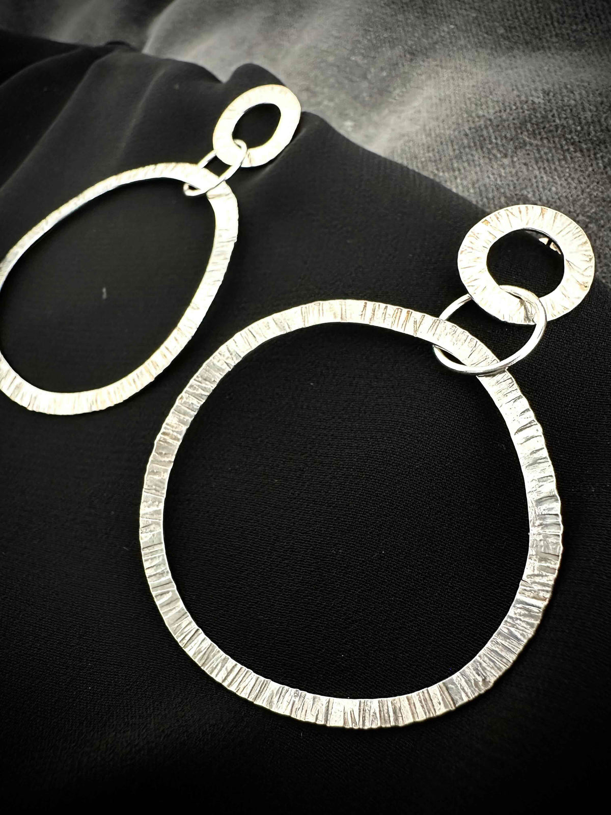 Hammered silver hoop earrings close-up - textured drop hoop detail