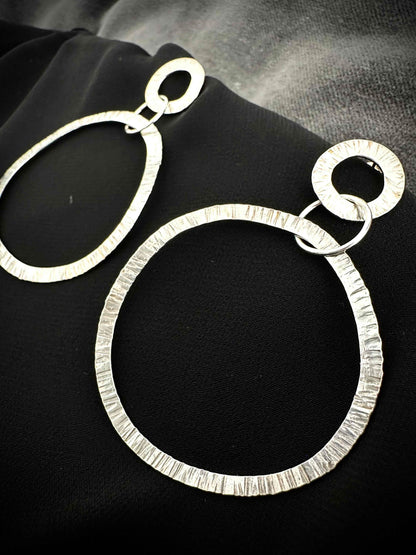 Hammered silver hoop earrings close-up - textured drop hoop detail