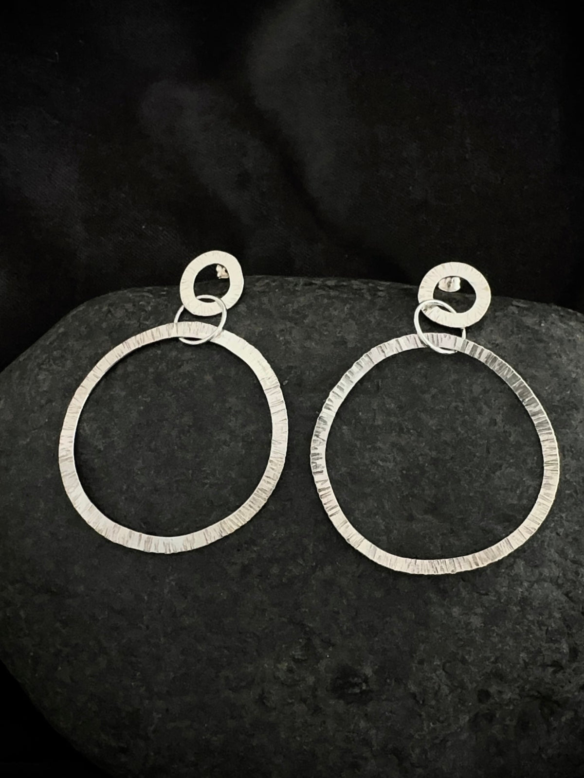 Textured silver drop hoop earrings on stone - hammered handmade jewelry