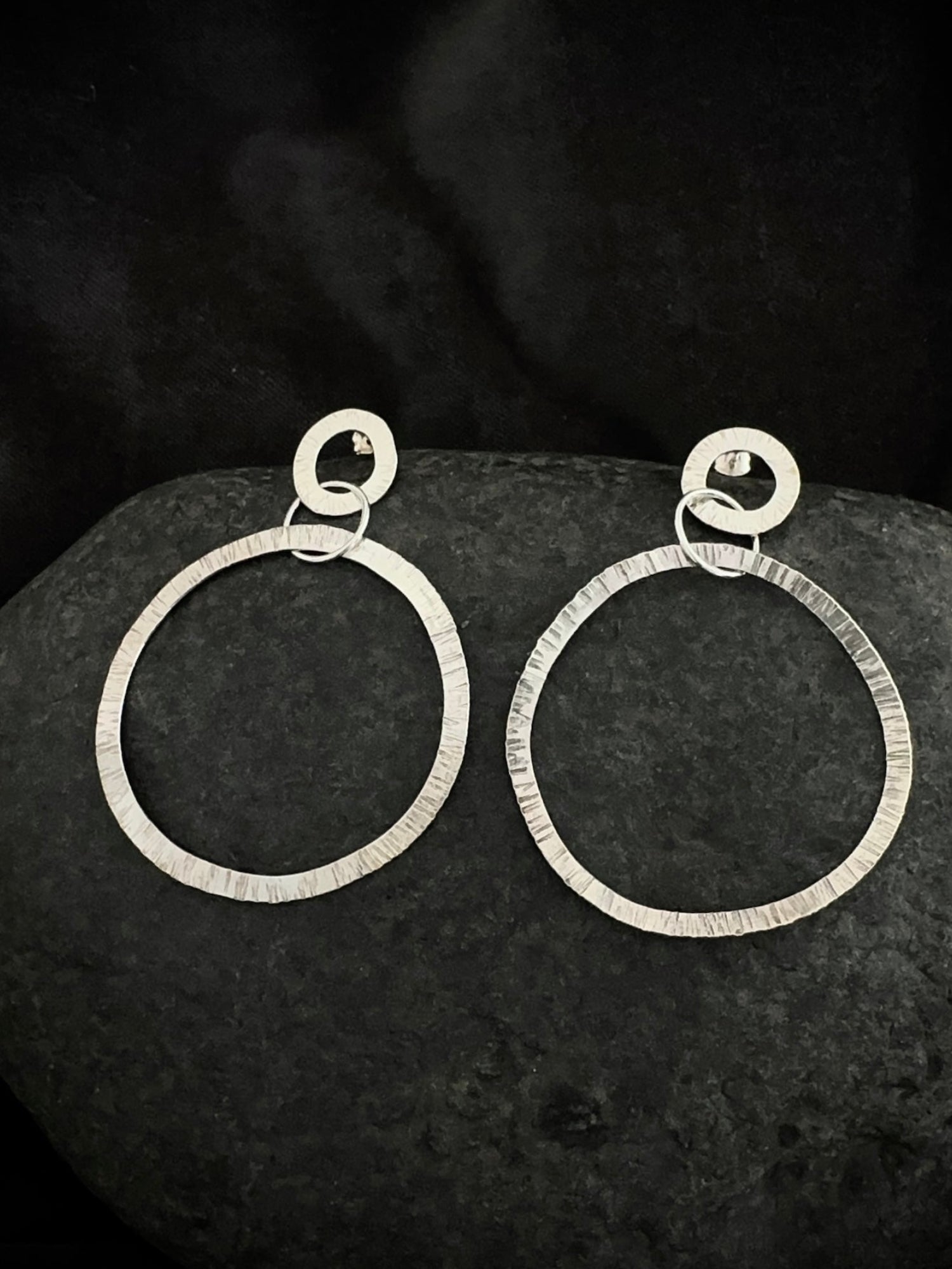 Textured silver drop hoop earrings on stone - hammered handmade jewelry